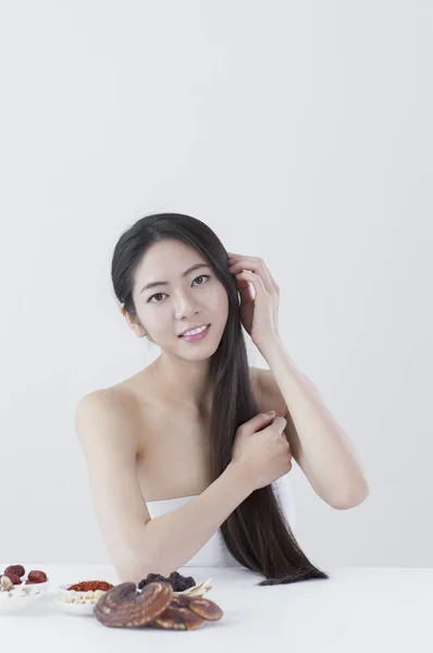 Μια Όμορφη Γυναίκα Της Ασίας Κρατώντας Μαλλιά Της Και Χαμογελά — Φωτογραφία Αρχείου