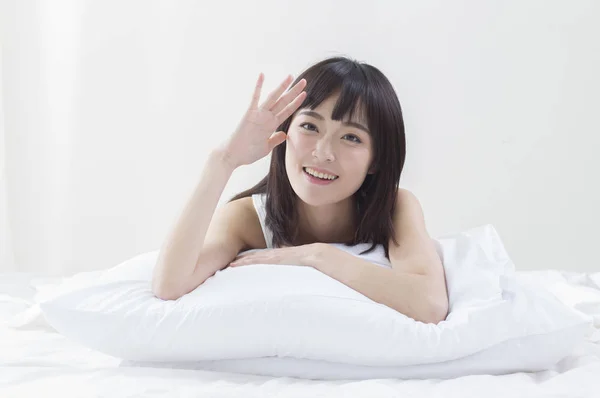 Asian female woman saluting on bed