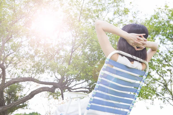 穿着白色衣服的年轻亚洲妇女坐在长凳上小睡 — 图库照片