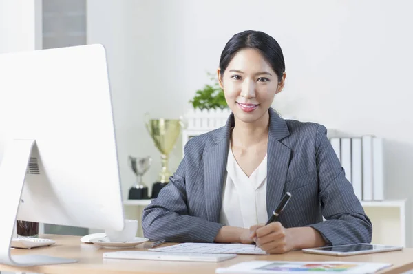 Jeune Femme Asiatique Assise Bureau Écrivant Souriant Caméra — Photo