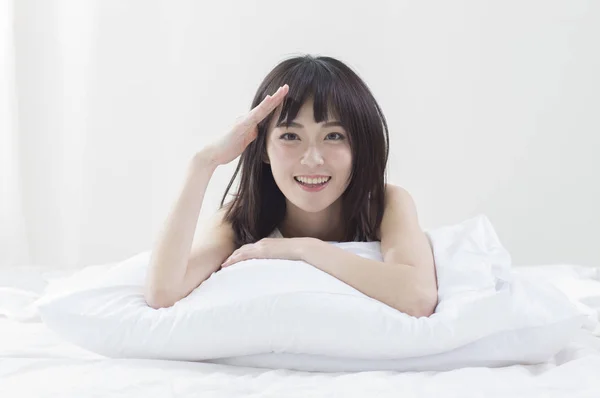 Asian female woman saluting on bed