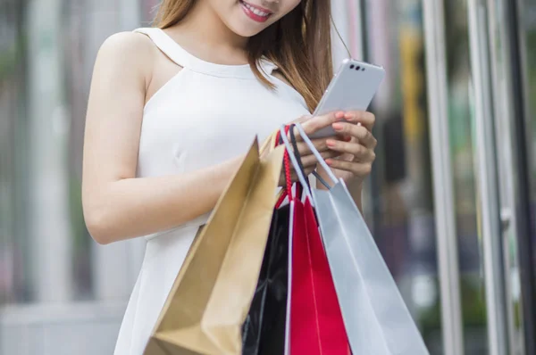 Joven Mujer Asiática Sosteniendo Algunas Bolsas Compras Sonriendo Usando Teléfono — Foto de Stock