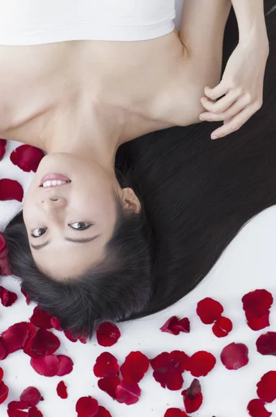 Uma Bela Mulher Asiática Deitada Sobre Algumas Rosas Sorrindo Para — Fotografia de Stock