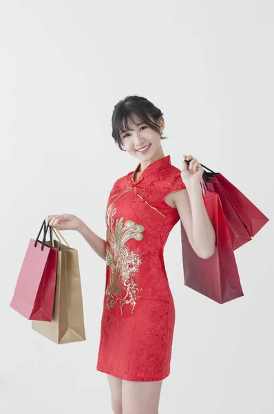 Mladá Čínská Žena Nosí Cheongsam Držení Některé Nákupní Tašky Usmívá — Stock fotografie