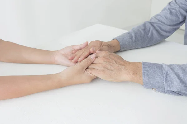 Asian elder man holding hands with nurse