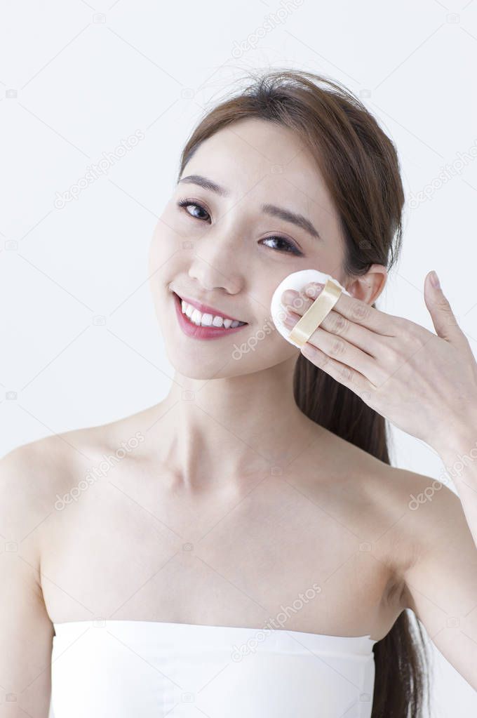 Young Asian woman smiling putting on makeups