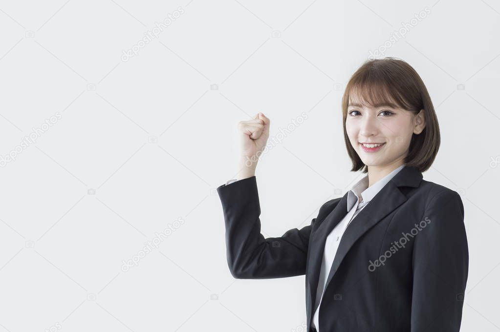 Young Asian woman wearing a suit hands up and smiling at the camera