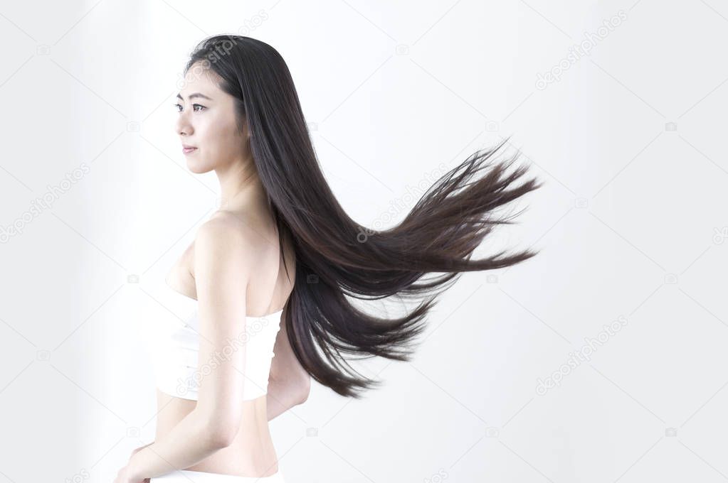 Young Asian woman with black long hair looking away