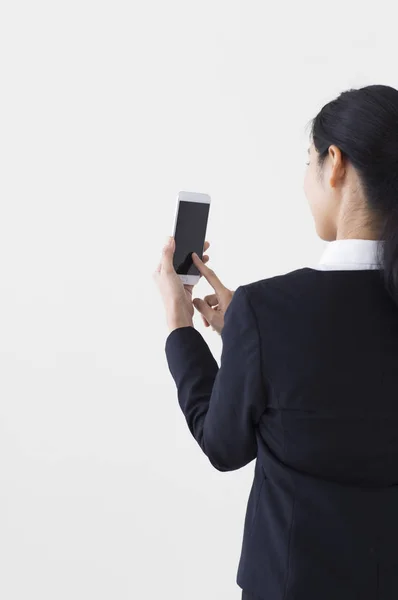 Jonge Aziatische Vrouw Dragen Een Pak Controleren Haar Mobiele Telefoon — Stockfoto