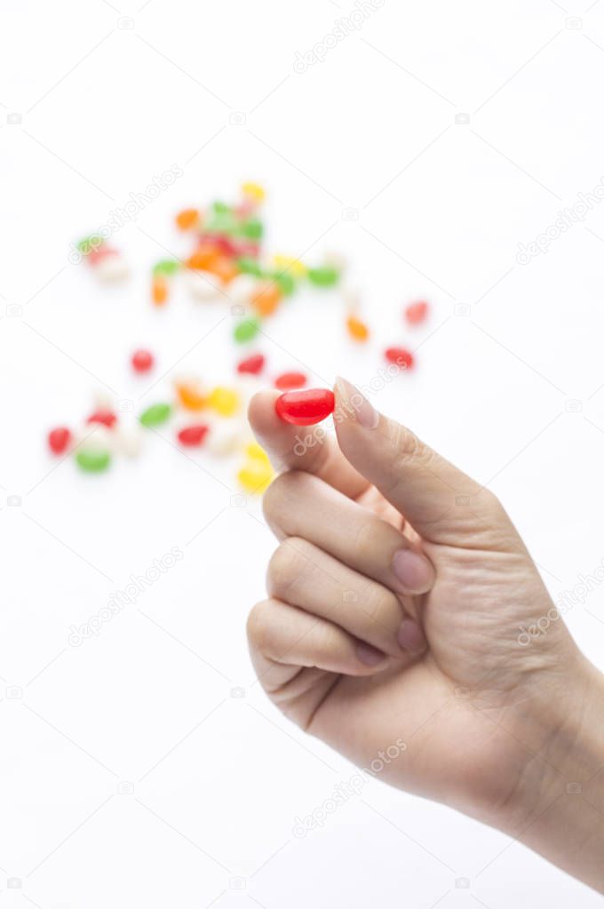 many tasty candies and hand on background,close up