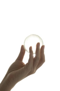 female hand holding glass ball isolated on white background