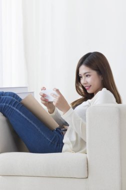 evde akıllı telefon ile genç Asyalı kadının portresi