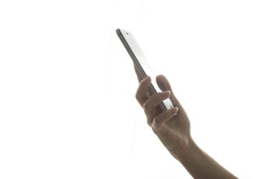 Beyaz arkaplanı olan akıllı telefonu tutan.