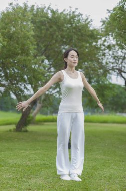 Güzel genç asyalı kadın parkta egzersiz yapıyor