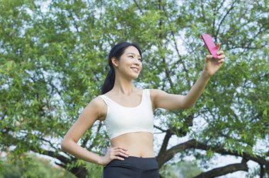 Güzel genç Asyalı kadın parkta selfie yapıyor