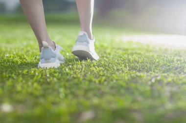Fitness ve sağlık kavramı. koşu ayakkabıları kadın çim üzerinde duran 