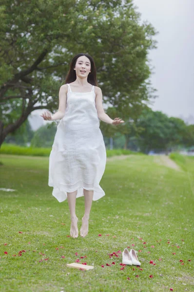夏の公園でジャンプ美しいアジアの女性 — ストック写真