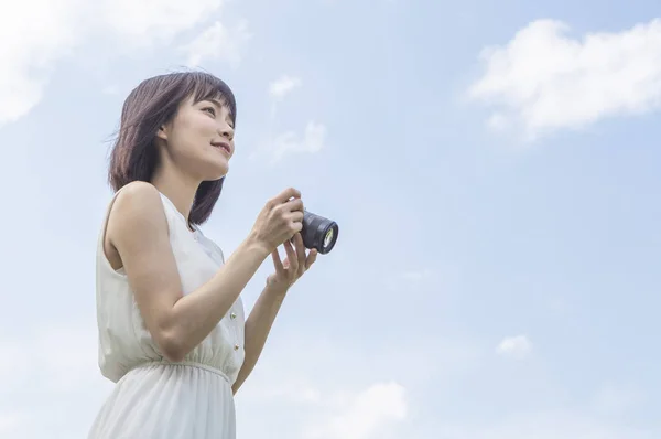 夏の公園でカメラ付きのドレスを着た若いアジアの女性 — ストック写真