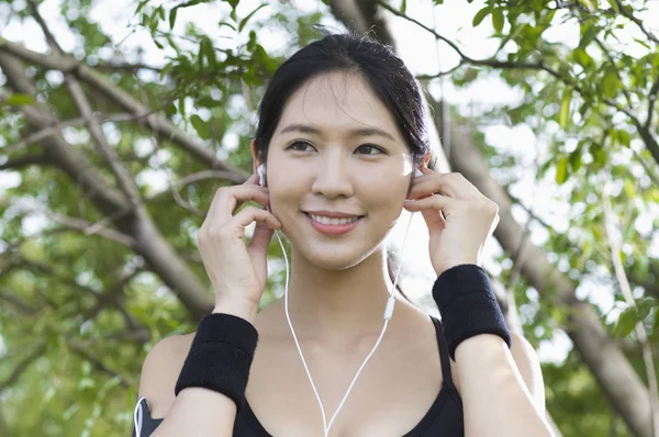 Όμορφη Νεαρή Ασιατική Γυναίκα Κάνει Άθλημα Στα Ακουστικά Στο Πάρκο — Φωτογραφία Αρχείου