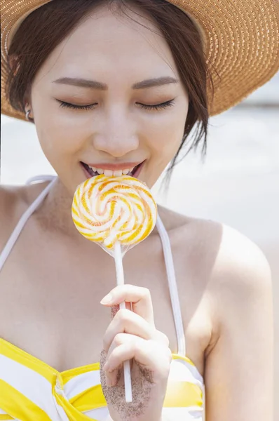 Beautiful Asian woman  with lollipop  on beach