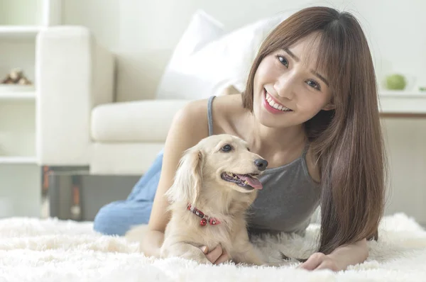 Young Asian woman with dog at home