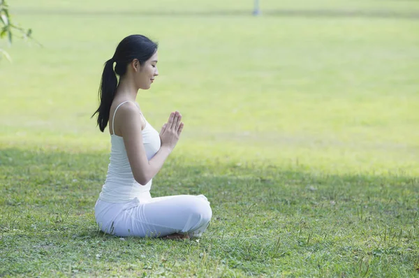 Young asian woman doing yoga or meditation  at summer