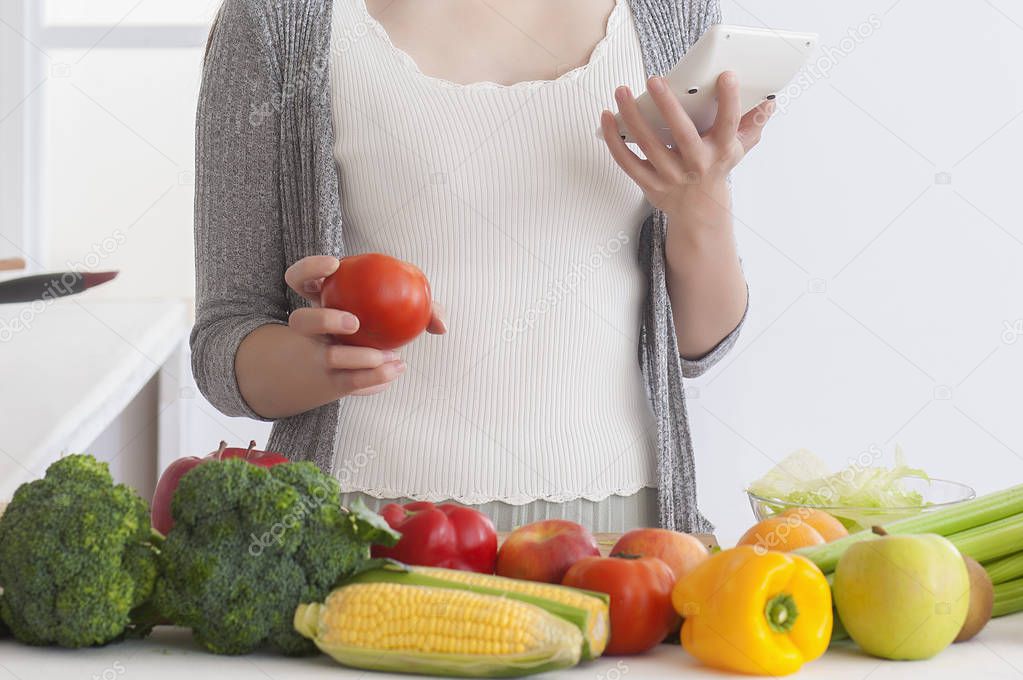 young woman using smartphone in kitchen 