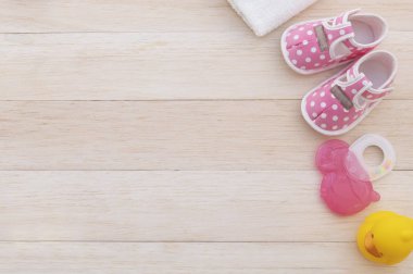 top view of baby clothes and accessories on wooden background with copy space