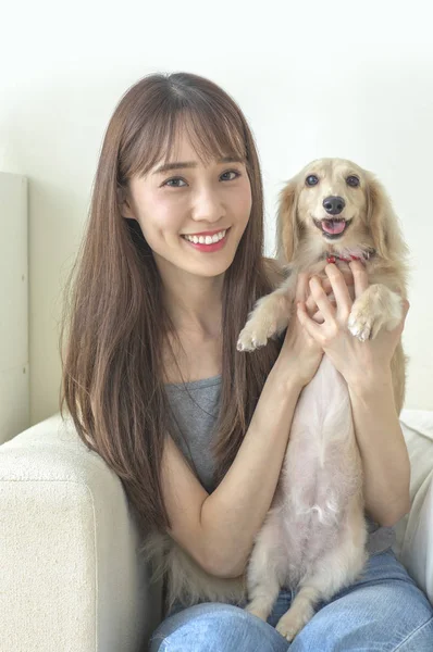 Young Asian woman with dog at home