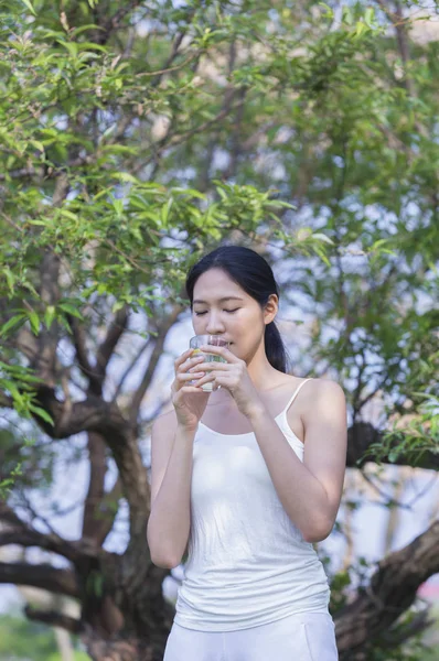 夏の公園で水を持つ若いアジアの女性 — ストック写真