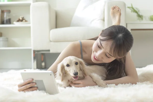 Young Asian woman with dog with tablet pc