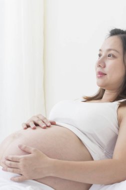 evde yatan genç Asyalı hamile kadın