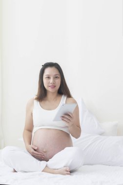 tablet pc ile genç Asyalı hamile kadın