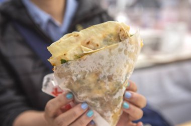 Lezzetli bir yemeğin yanında sandviç yiyen birinin fotoğrafını çek.