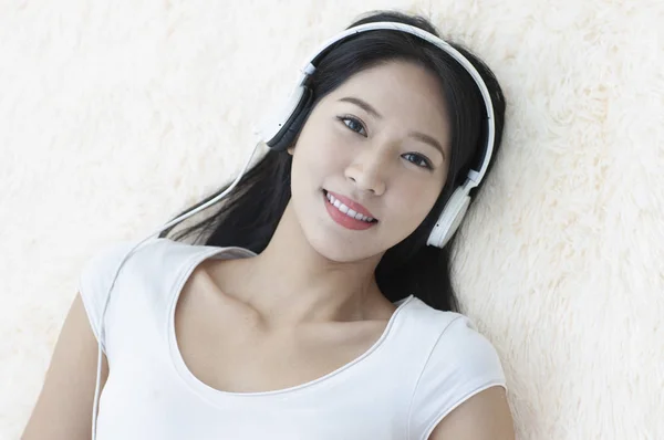 Beautiful Asian woman  listing music in headphones