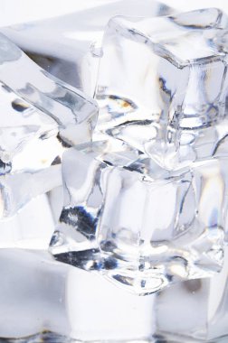 Beyaz zemin üzerinde kristal berrak buz küpleri.