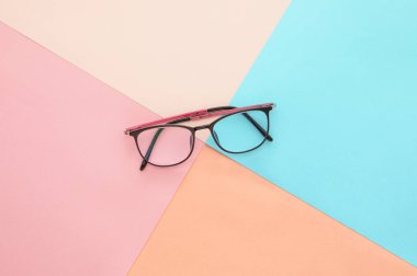 top view of eyeglasses on colored background