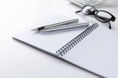 defter ve kalem beyaz zemin üzerine