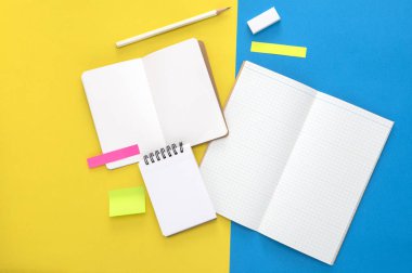 blank notebook with paper notes on colored background