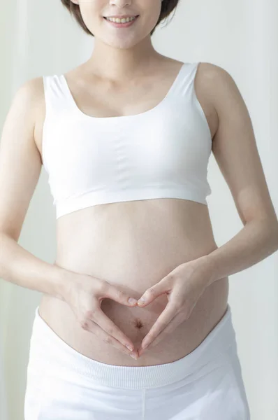 若いです妊娠中のアジアの女性保持彼女の腹 — ストック写真