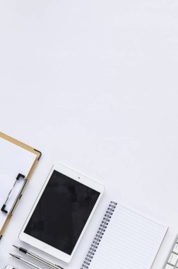 tablet bilgisayar, defter, beyaz masadaki kalemler