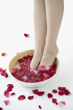 Spa salonundaki kadın, gül yapraklı ayaklar 