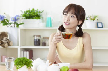 Mutfakta çay içen genç bir kadının portresi.