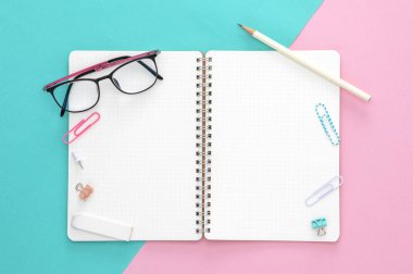 Renkli bir arkaplanda gözlük ve not defteri