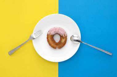 top view of donut on plate on colored background