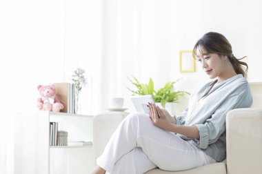 Evde tablet kullanan genç bir kadının portresi