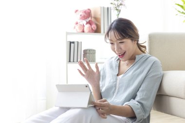 Evde tablet kullanan genç bir kadının portresi