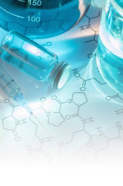 kimyasal laboratuvarda mavi sıvı ve şırınga ile şişeler