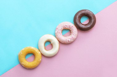 Pembe ve mavi arkaplanda renkli çörekler