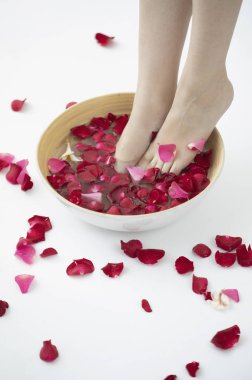 Spa salonundaki kadın, gül yapraklı ayaklar  